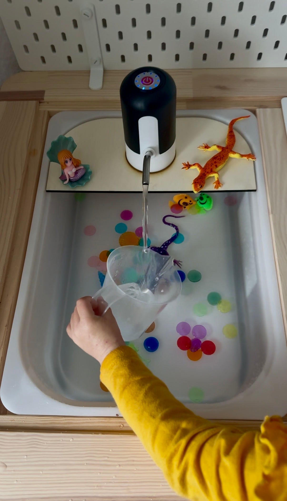 Elektrická pumpička na vodu pro děti umístěná nad herní vaničkou